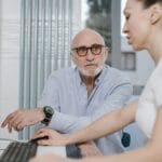 Starszy mężczyzna rozmawia z lekarzem w gabinecie o problemach zdrowotnych